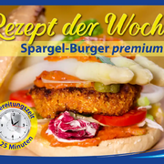 Ein aufgeschnittener Premium-Burger mit veganem Patty, geschmolzenem Käse, frischem Salat, Tomaten, Zwiebeln und mehreren Stangen gekochtem weißem Spargel auf einem getoasteten Brötchen.